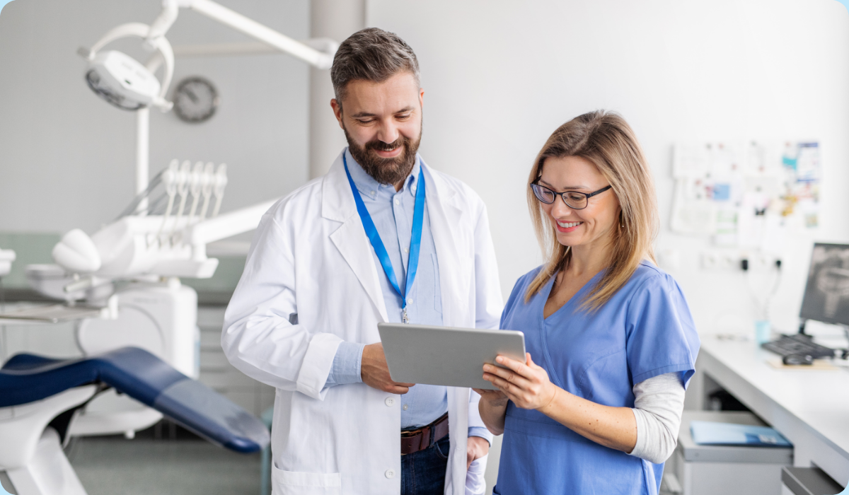 Dentist and dental assistant reviewing cases